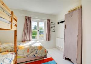 a bedroom with two bunk beds and a window at BackToFront Cottage in Briston