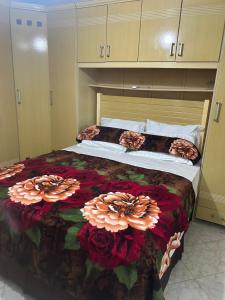 Un dormitorio con una cama grande con flores. en Suítes da Erô, en Arraial do Cabo