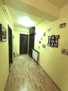 una stanza vuota con un corridoio con immagini appese al muro di Stejarului Apartament a Floreşti