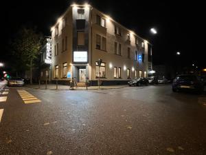 a building on a street at night with cars parked outside at Hotel Gambrinus in Pachten