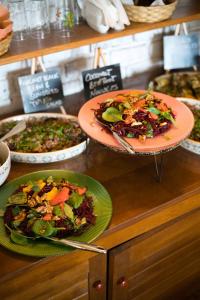 un comptoir avec deux assiettes de nourriture et une salade dans l'établissement Akasha Retreat - Nature, Yoga & Wellness, Healthy Food & Drinks, à Peştera