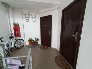 un corridoio con due porte marroni e una bicicletta di Stejarului Apartament a Floreşti