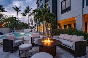 a patio with a table and chairs and a pool at Courtyard by Marriott - Naples in Naples