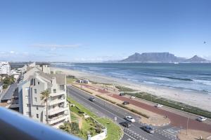 a view of the beach from the balcony of a building at Portico 704 in Bloubergstrand