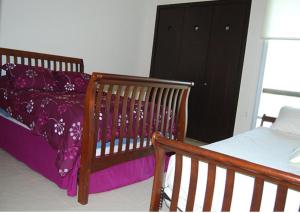 ein Schlafzimmer mit einem Kinderbett und einem schwarzen Schrank in der Unterkunft Casa Mccraren Torre 3-302 at Mayan Lakes in Playa Encanto