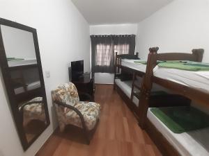 a room with two bunk beds and a chair at POUSADA MALU in Bragança Paulista +3 photos