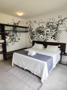 um quarto com uma cama grande e uma parede decorativa em Villa dos Graffitis Pousada em Morro de São Paulo