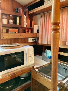 a small kitchen with a microwave and a counter at Disfruta del mar cerca de Barcelona in Castelldefels