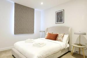 a bedroom with a white bed and a table at 2 Bedroom 2 Bathroom Cosy Apartment - Zone 1 - Central London in London