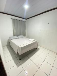 a bedroom with a bed in a white room at Hoje Apartamentos in Feira de Santana