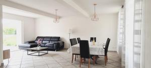 salon ze stołem i kanapą w obiekcie Le Rouge Gorge à 12 minutes d'Eurexpo w mieście Genas