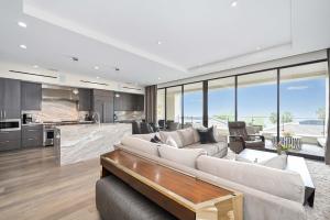 a living room with a large couch and a kitchen at True Luxury Living in Fashion Island with Elevator and Ocean Views in Newport Beach