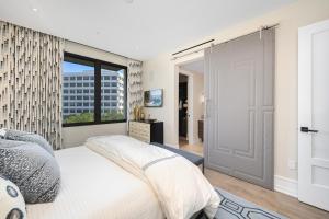 1 dormitorio con cama y ventana grande en True Luxury Living in Fashion Island with Elevator and Ocean Views en Newport Beach