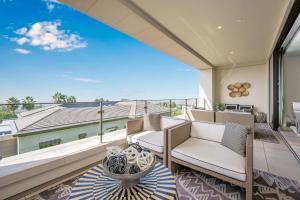 a balcony with two chairs and a large window at True Luxury Living in Fashion Island with Elevator and Ocean Views in Newport Beach