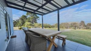 a picnic table on the porch of a house at Manfield Seaside Bruny Island in Alonnah