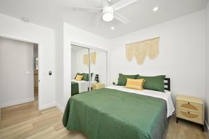 a bedroom with a green bed and a ceiling fan at Sunset Beach Retreat next to Water Tower and Ocean in Sunset Beach