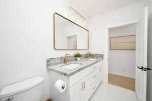 a white bathroom with a sink and a mirror at Sunset Beach Retreat next to Water Tower and Ocean in Sunset Beach