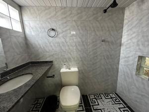 La salle de bains est pourvue de toilettes blanches et d'un lavabo. dans l'établissement 3D Hotel, à Manaus