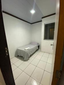 a small white room with a bed in it at Hoje Apartamentos in Feira de Santana