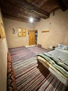 1 dormitorio con cama y alfombra grande en La Siwa, en Siwa
