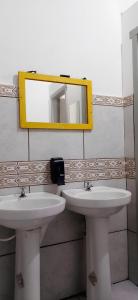 a bathroom with two sinks and a mirror at Hostel Bahia in Porto Alegre