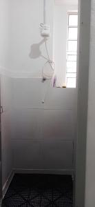 a shower in a white bathroom with a window at Hostel Bahia in Porto Alegre