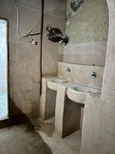 a dirty bathroom with a sink and a shower at La Siwa in Siwa
