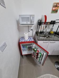 a small refrigerator in a kitchen with a microwave at Studio fantástico in São Paulo