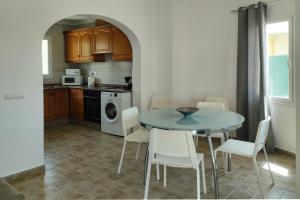 uma cozinha com uma mesa e cadeiras numa cozinha em Villa Anturium by Villa Plus em Beniarbeig