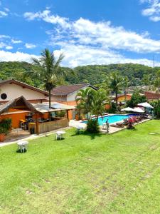 ein Haus mit einem Garten mit Pool in der Unterkunft Pousada Dolce Vita in Itanhaém