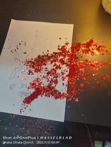 a pile of red glitter on a piece of paper at JA INT in Dhaka