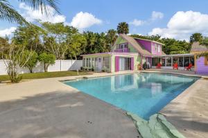 une maison avec une piscine en face d'une maison dans l'établissement 2 BR Jensen Beach Tropical Resort, à Fort Pierce