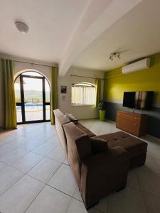 a living room with a couch and a flat screen tv at Wardina Holiday Home Maisonette in Munxar