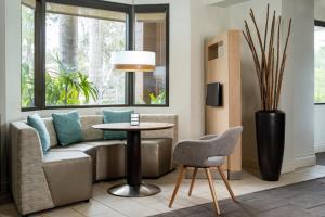 a living room with a couch and a table at Courtyard by Marriott - Naples in Naples +52 photos