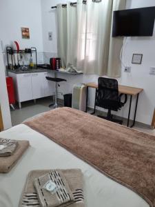 a room with a bed with a desk and a table at Studio fantástico in São Paulo