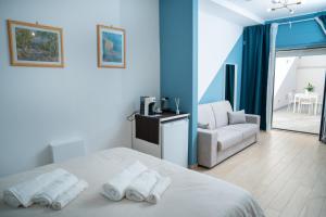 ein Schlafzimmer mit einem Bett, einem Sofa und einem Stuhl in der Unterkunft PALAZZO ENNIO in Bari