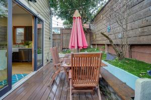 a table with two chairs and a pink umbrella on a deck at San Francisco Home with Bay Views Near Union Square! in San Francisco