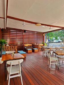 a restaurant with wooden floors and tables and chairs at Taj Maza Sunset Villas in Gili Trawangan