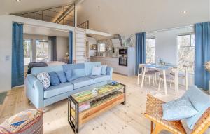 Cozy Home In Uddevalla With House Sea View في Sundsandvik: غرفة معيشة مع أريكة زرقاء وطاولة