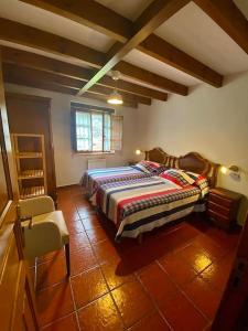 a bedroom with a bed and a chair in it at La Rotella, calma al lado de Cangas de Onís in Cangas de Onís
