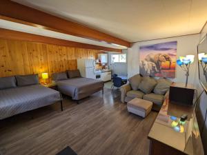 a living room with a couch and a bed and a table at Deerview Lodge & Cabins - Princeton BC in Princeton