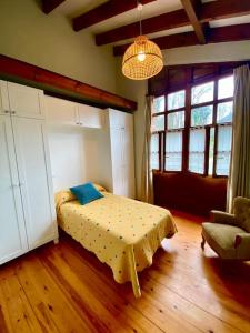a bedroom with a bed and a couch and windows at La Rotella, calma al lado de Cangas de Onís in Cangas de Onís