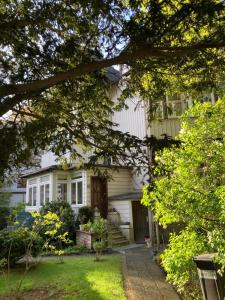 a white house with a porch and a yard at Mini-Appartements am Burgberg in Bad Harzburg