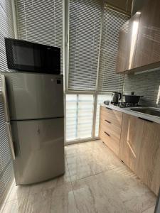 La cuisine est équipée d'un réfrigérateur et d'un évier. dans l'établissement mimi, à Tbilissi