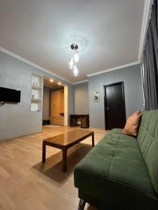 - un salon avec un canapé vert et une table dans l'établissement mimi, à Tbilissi