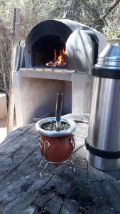 a fire oven with a pot and a pot with a stove at la soñada in Villa Icho Cruz