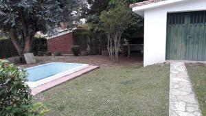 a swimming pool in a yard next to a house at la soñada in Villa Icho Cruz