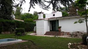 a white house with a picnic table in the yard at la soñada in Villa Icho Cruz