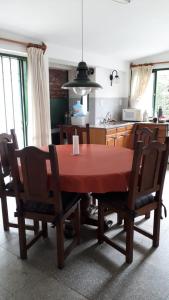 a dining room table with chairs and a kitchen at la soñada in Villa Icho Cruz