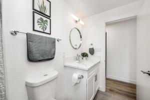 Baño blanco con aseo y lavamanos en Spacious Home with 7 Beds minutes from Mission Bay, en San Diego